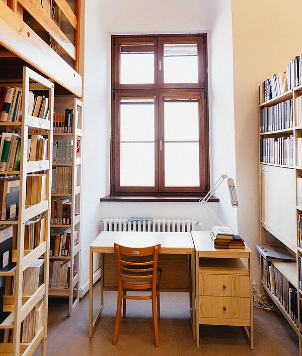 Eine Bibliothek mit einem Arbeitsplatz unter einem Fenster