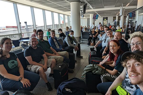 viele Leute sitzen und warten in Flughafen