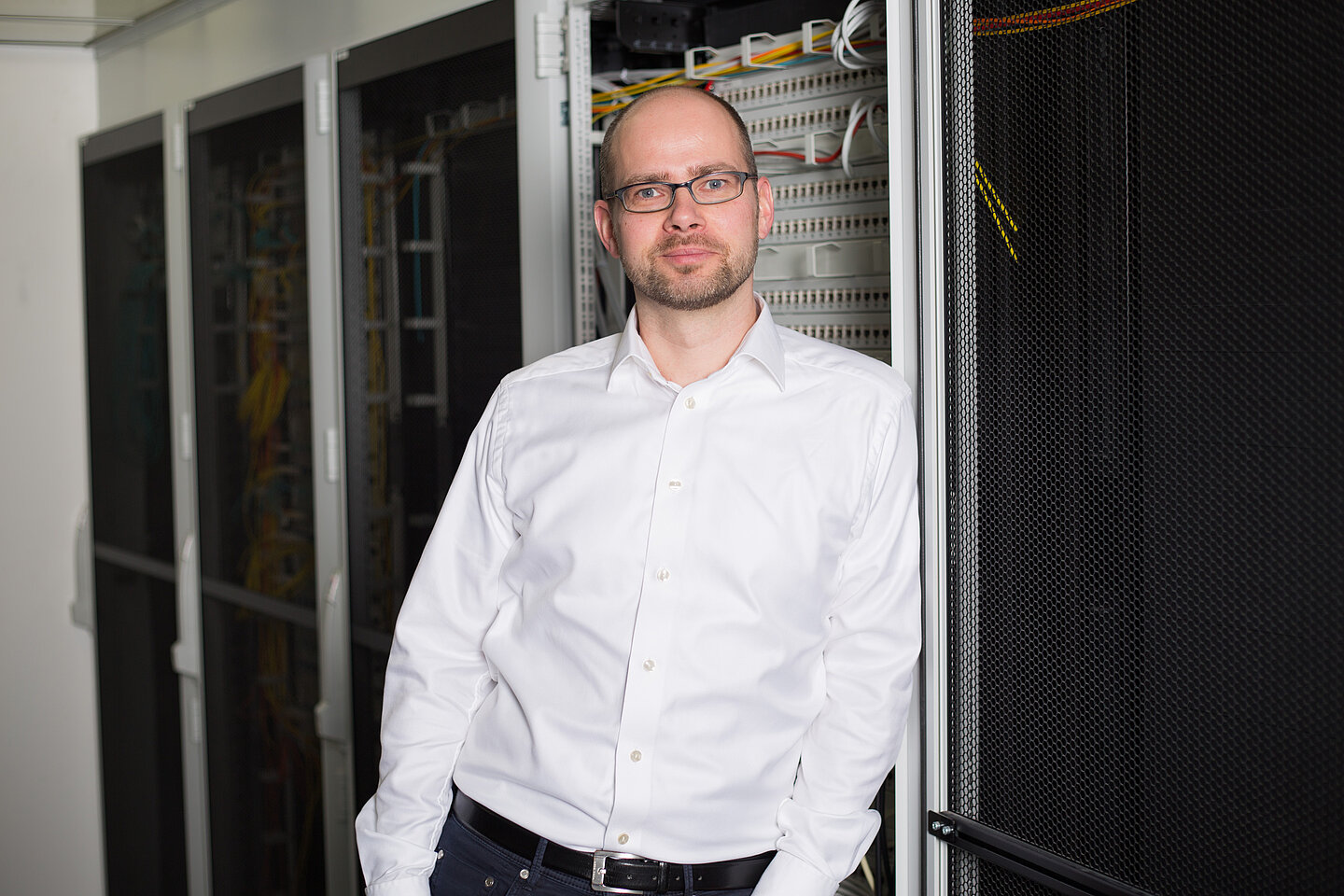 Dr.-Ing. Gerold Bausch steht in einem Serverraum