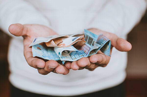 (Foto: Christian Dubovan/unsplash) Zwei Hände voller Geldscheine (Euro)