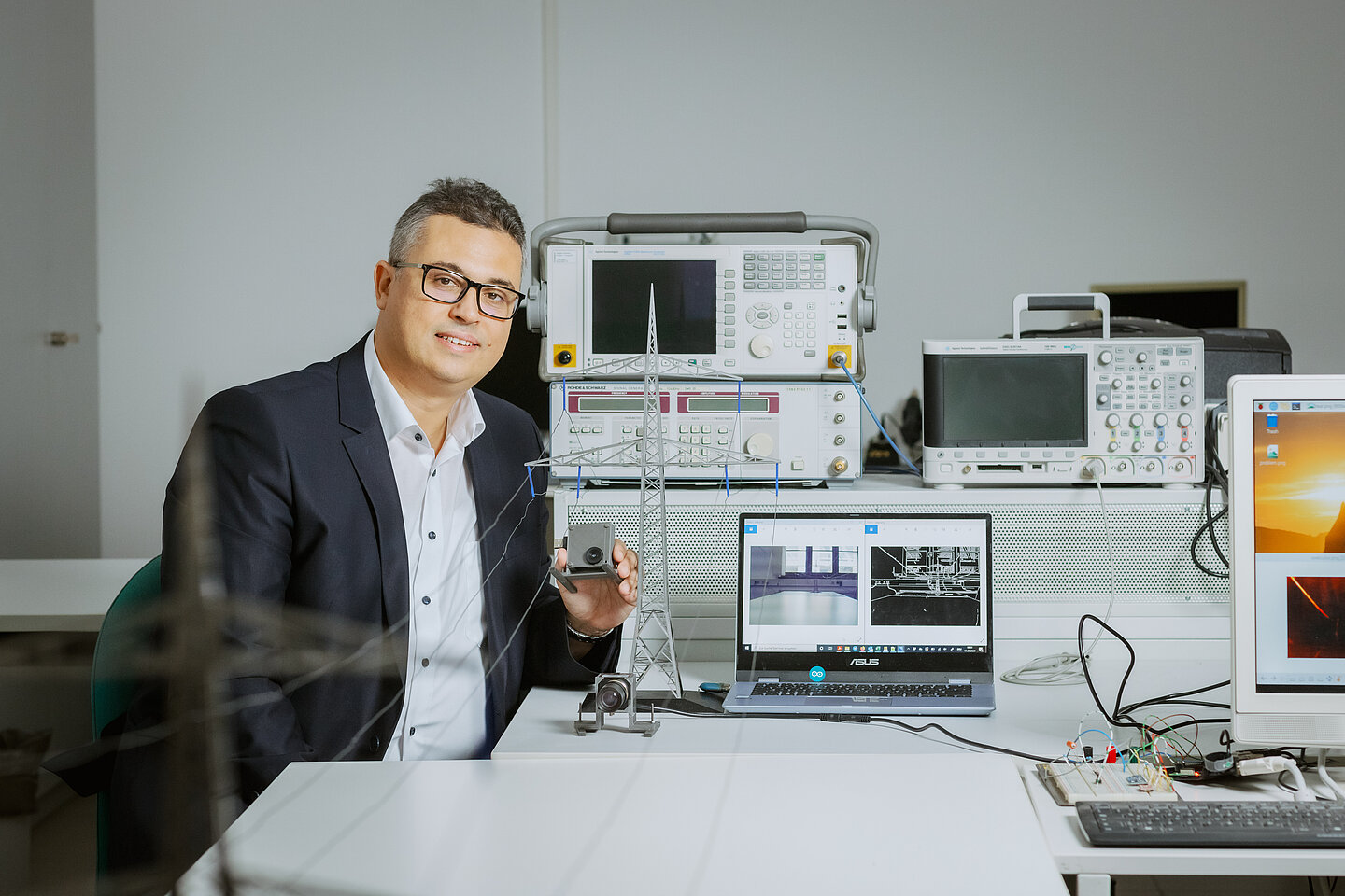 Prof. Faouzi Derbel zeigt, wie die Messeinrichtung mittels intelligenter Bildverarbeitung den maximalen Durchhang von Stromleitungen erkennen soll (Bild: Stephan Flad / HTWK Leipzig) Prof. Faouzi Derbel zeigt, wie die Messeinrichtung mittels intelligenter Bildverarbeitung den maximalen Durchhang von Stromleitungen erkennen soll (Bild: Stephan Flad / HTWK Leipzig)