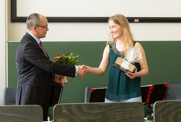 Mann gratuliert Frau in Hörsaal