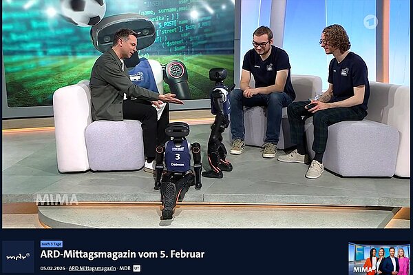 Im Fernsehstudio interagiert Moderator Tino Böttcher sichtlich begeistert mit einem der beiden HTWK Roboten im Gespräch mit Felix Loos und Johannes Walter. 