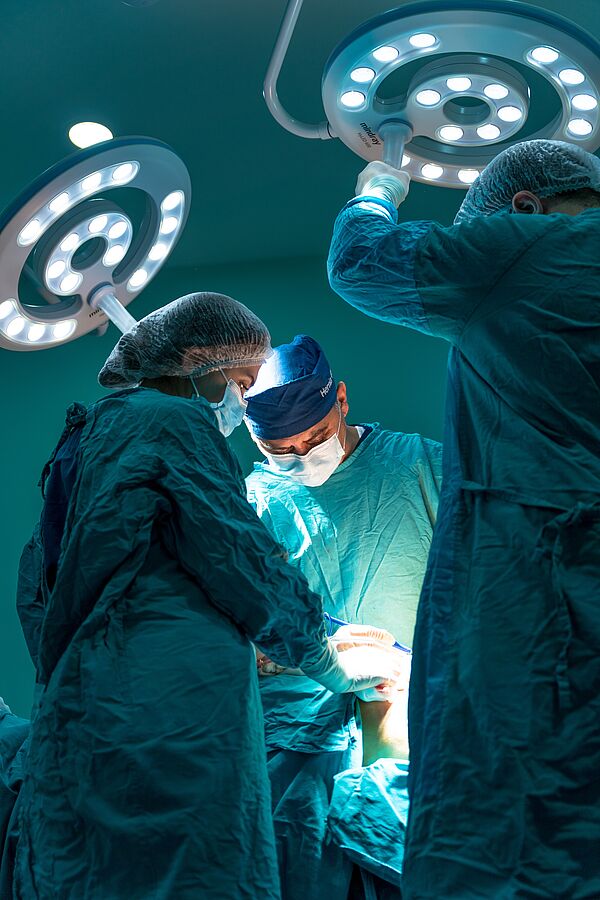 Drei Mediziner operieren einen Patienten. LED-Lampen sorgen dabei für eine gute Beleuchtung.
