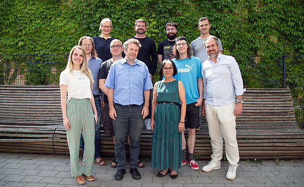 DINOBBIO Team Brasilianische und deutsche Forschende versammeln sich zum Teamfoto vor einer grünen Wand