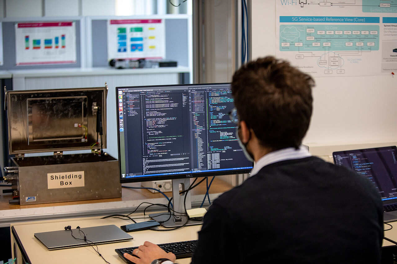 Symbolbild, Wissenschaftlicher Mitarbeiter sitzt vor Monitoren im Masterlabor Hochfrequenztechnik
