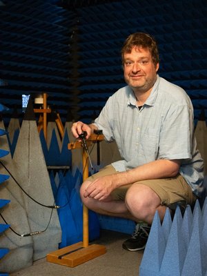 Absorberkammer Prof. Robert Geise instaliert Antennen einer mobilen Basisstation in der Absorberkammer. Er hockt und hält eine Antenne in der Hand