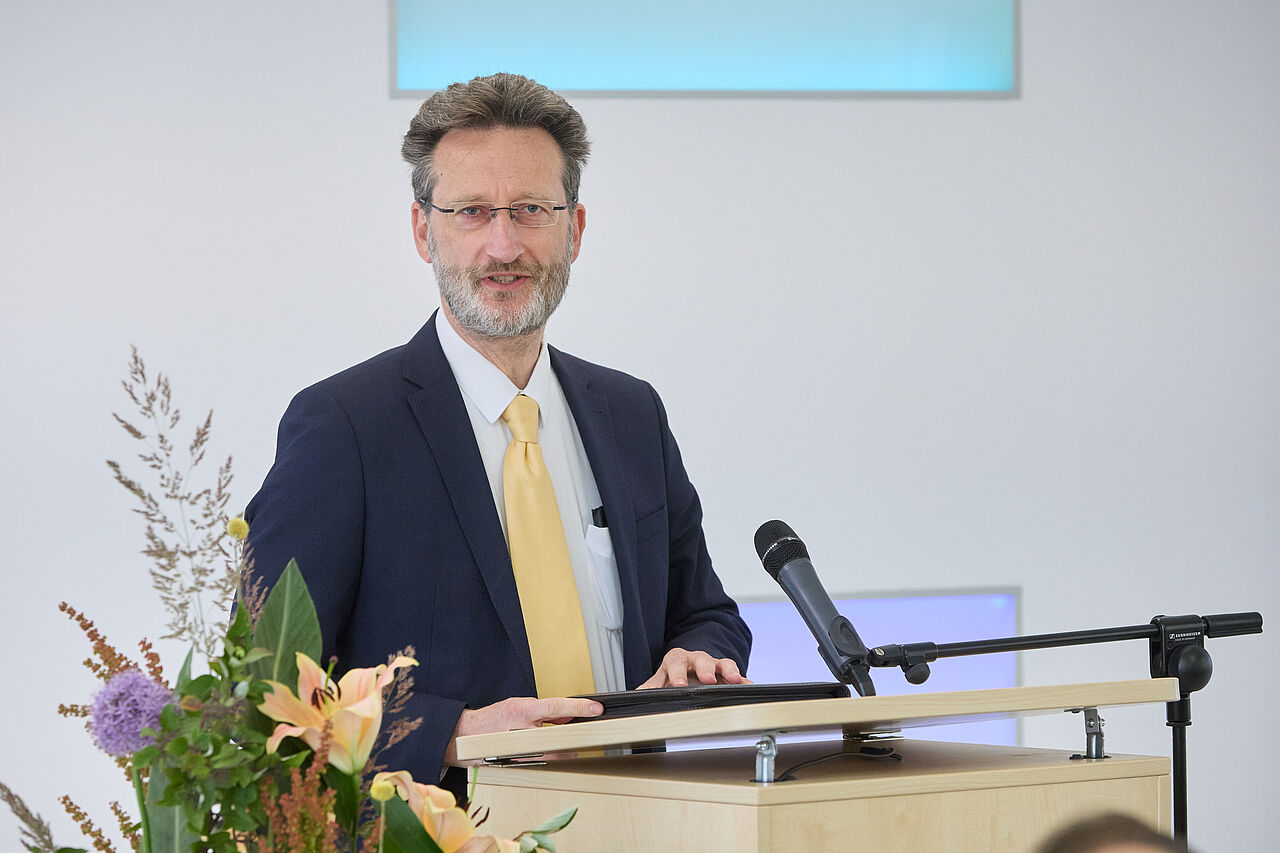 Prof. Jean-Alexander Müller hält Grußwort am Rednerpult