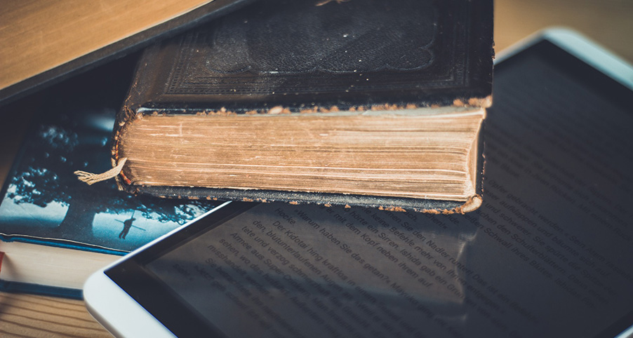 E-Book und antiquarisches Buch auf einem Stapel