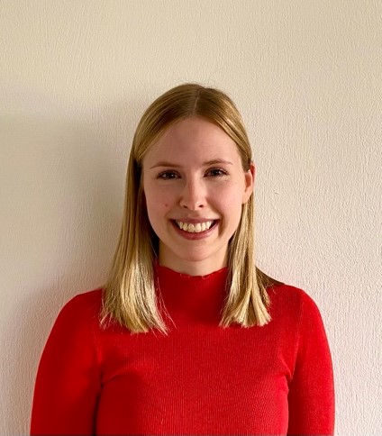 junge Frau im roten Oberteil lächelt in die Kamera